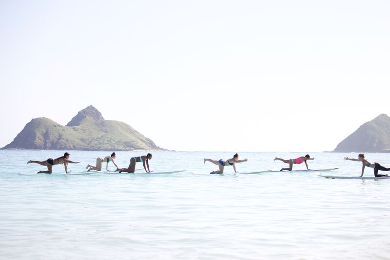 Commit to Fit; Jenny Giblin balancing on surfboard over water